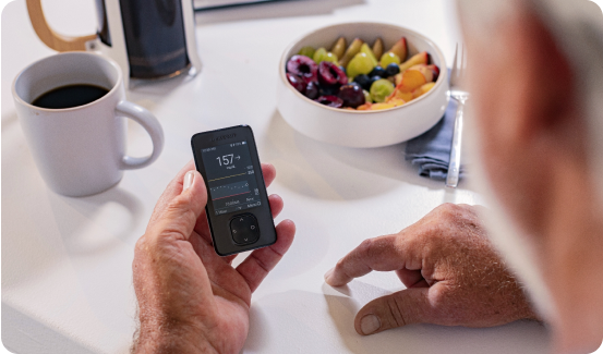 Dexcom CGM user looking at the Dexcom G7 app while eating breakfast